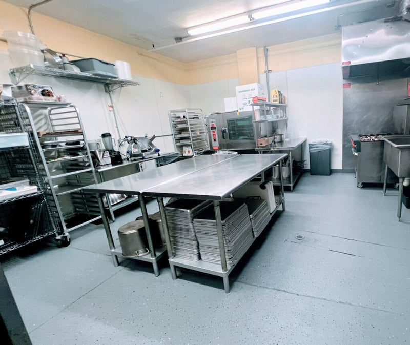 Commercial kitchen with stainless steel equipment and prep tables for efficient food production