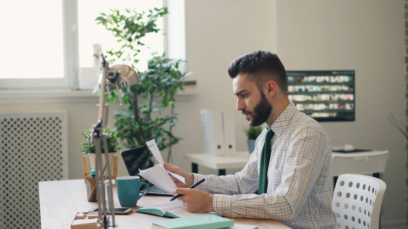 Man working on a laptop in a licensed commercial kitchen setting