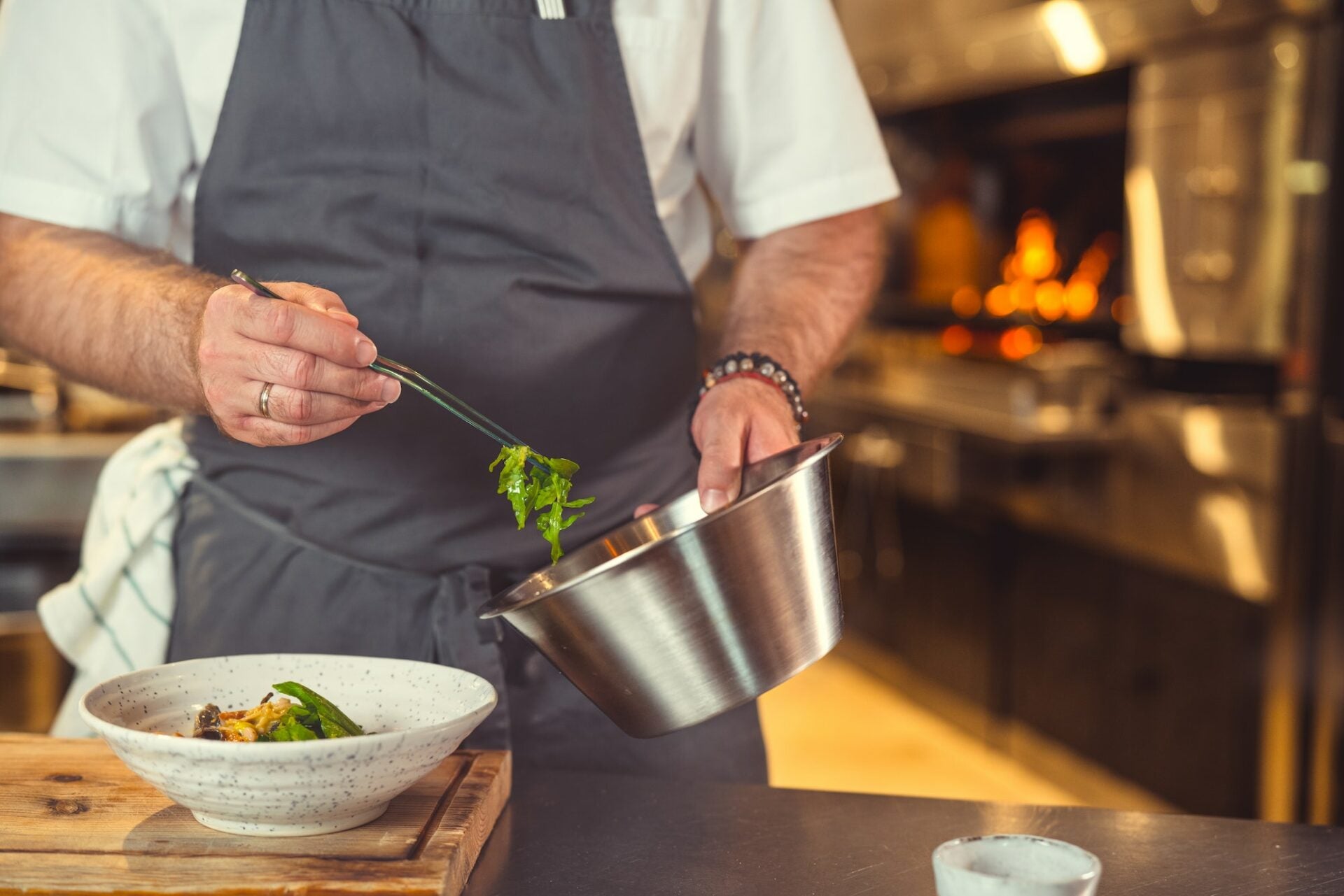 Chef preparing a gourmet dish in a professional kitchen – background image for Le Gourmet Factory hero section