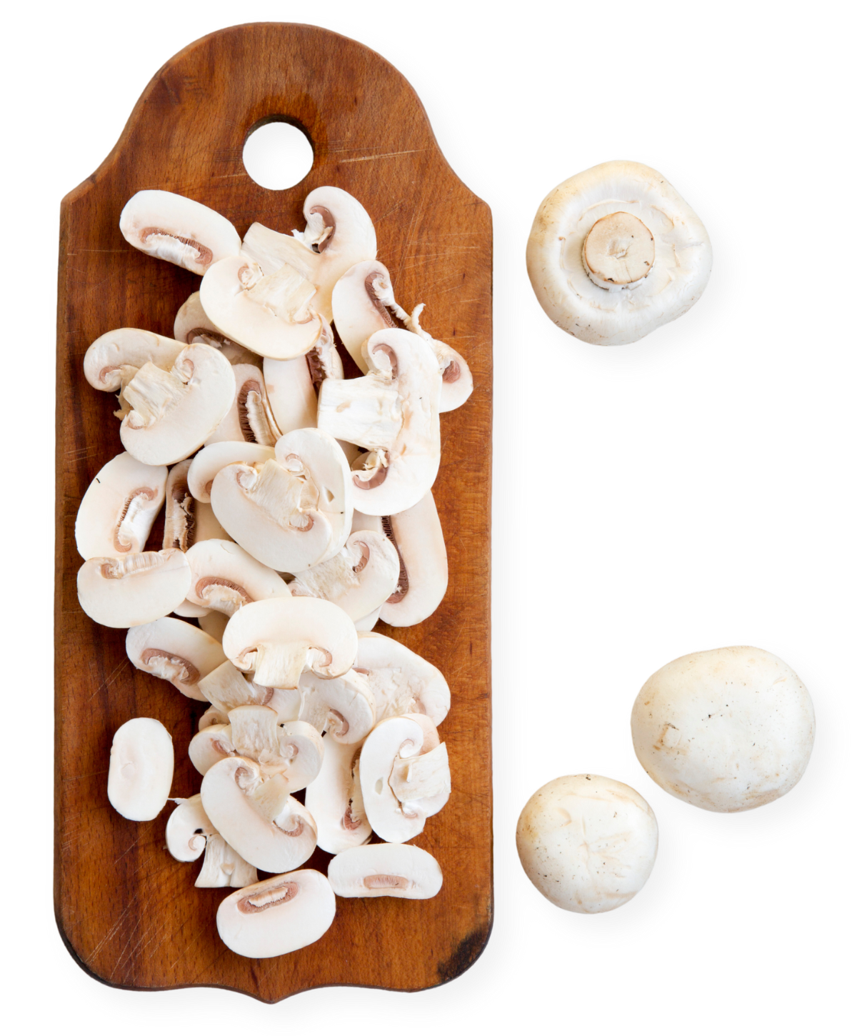 Sliced white mushrooms arranged on a wooden cutting board with whole mushrooms alongside
